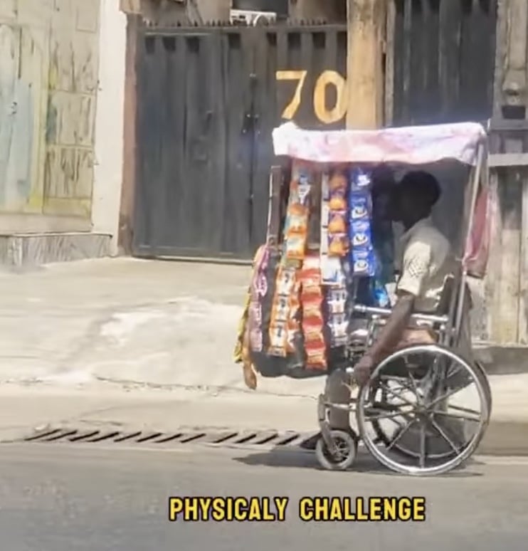 Physically challenged man selling goods from wheelchair 